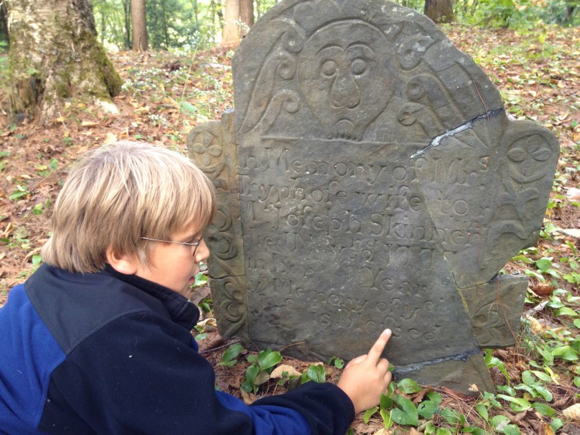 Andy inspects gravestone at Gilbert Cemetary
