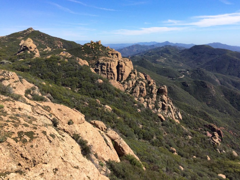 Sandstone Peak in sight - the high point of the hike ahead - with a group of hikers on the bump in middle ground.