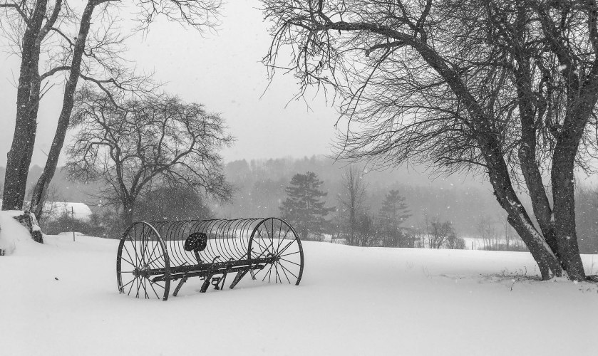 An old farm instrument on a farm in Lyme, on a snowy day.