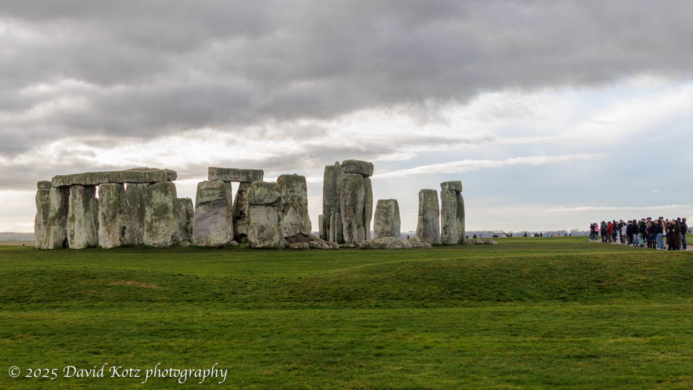 view of Stonehenge, with a small crowd of people nearby