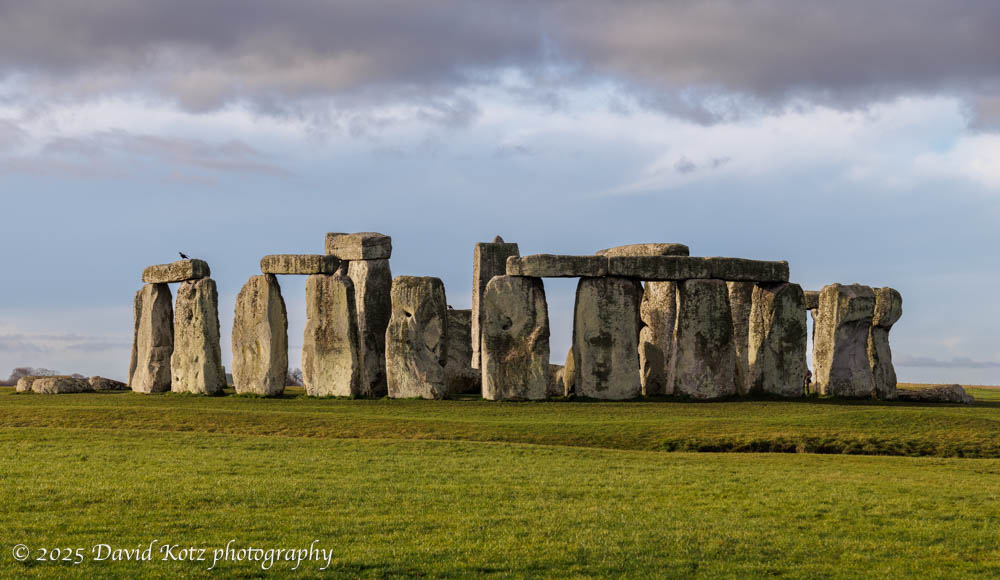 Stonehenge, with moody clouds and sunshine on the stones and grass