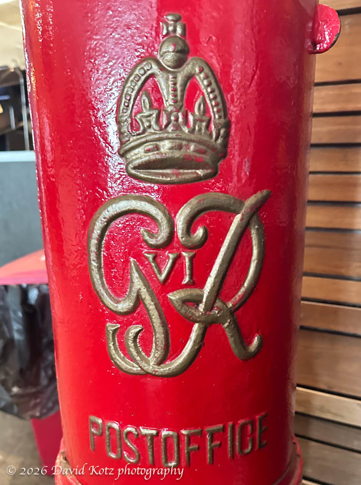 gold-painted crown, cypher, and label on King George VI postbox.